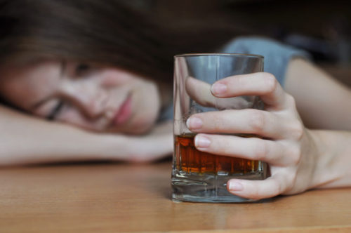 Drunk female with a glass of whiskey