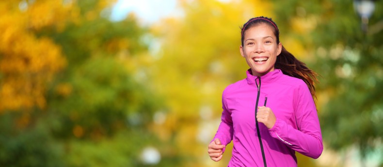 Female jogger. Fit young Asian woman jogging in park smiling hap